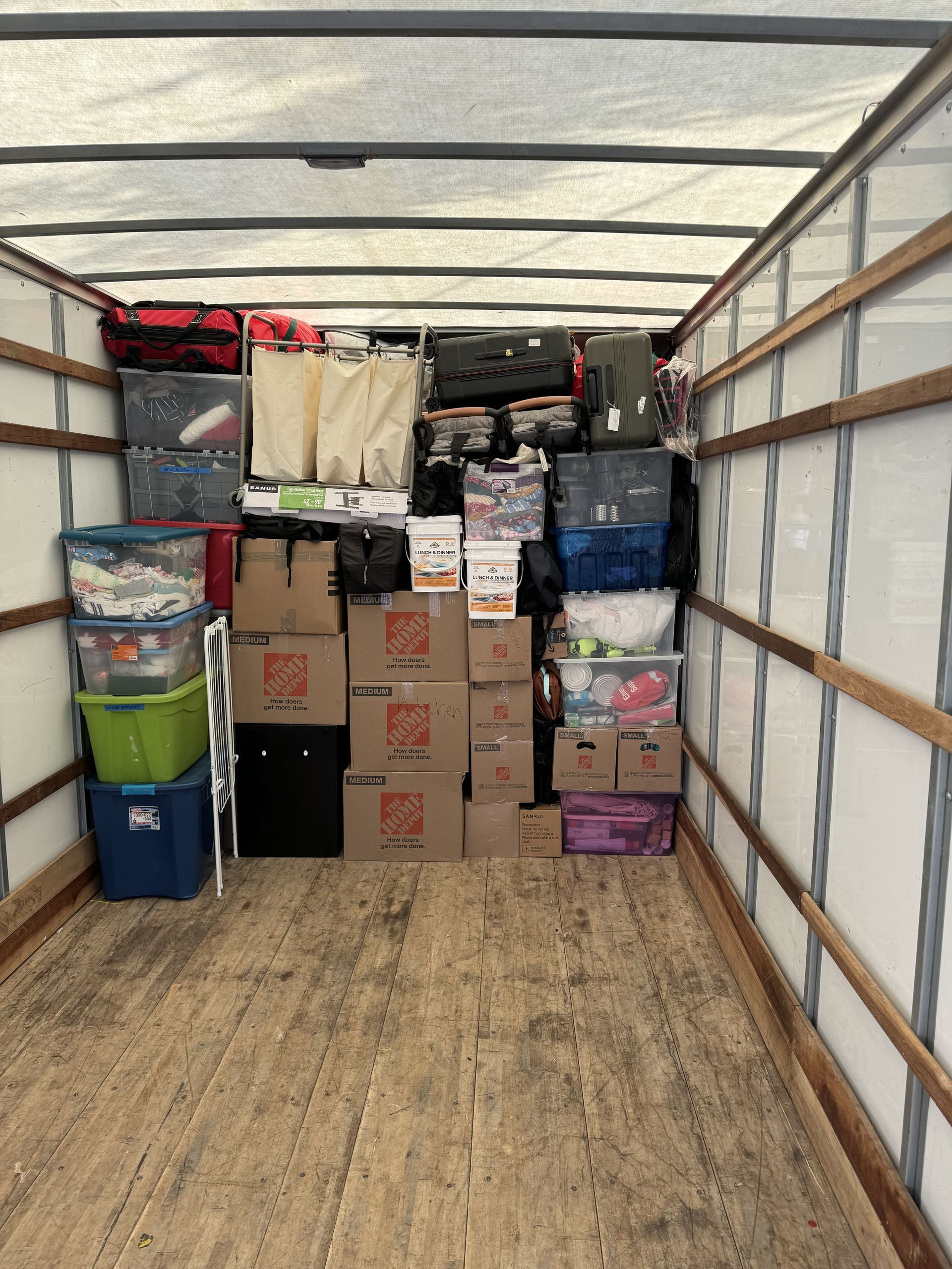 Moving truck interior packed with boxes and miscellaneous items.