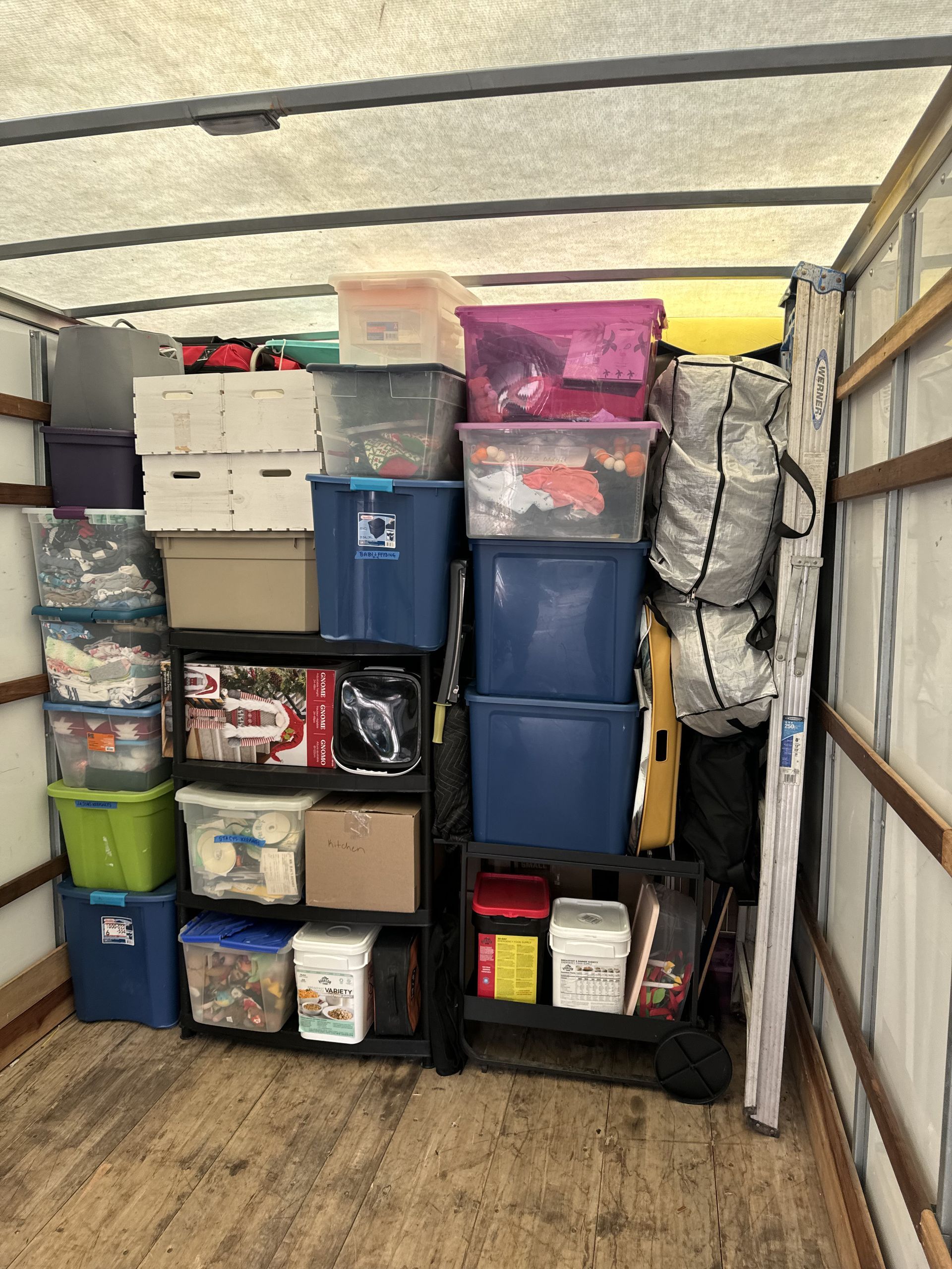 Boxes and items packed inside a moving truck; various sizes, colors stacked tightly.
