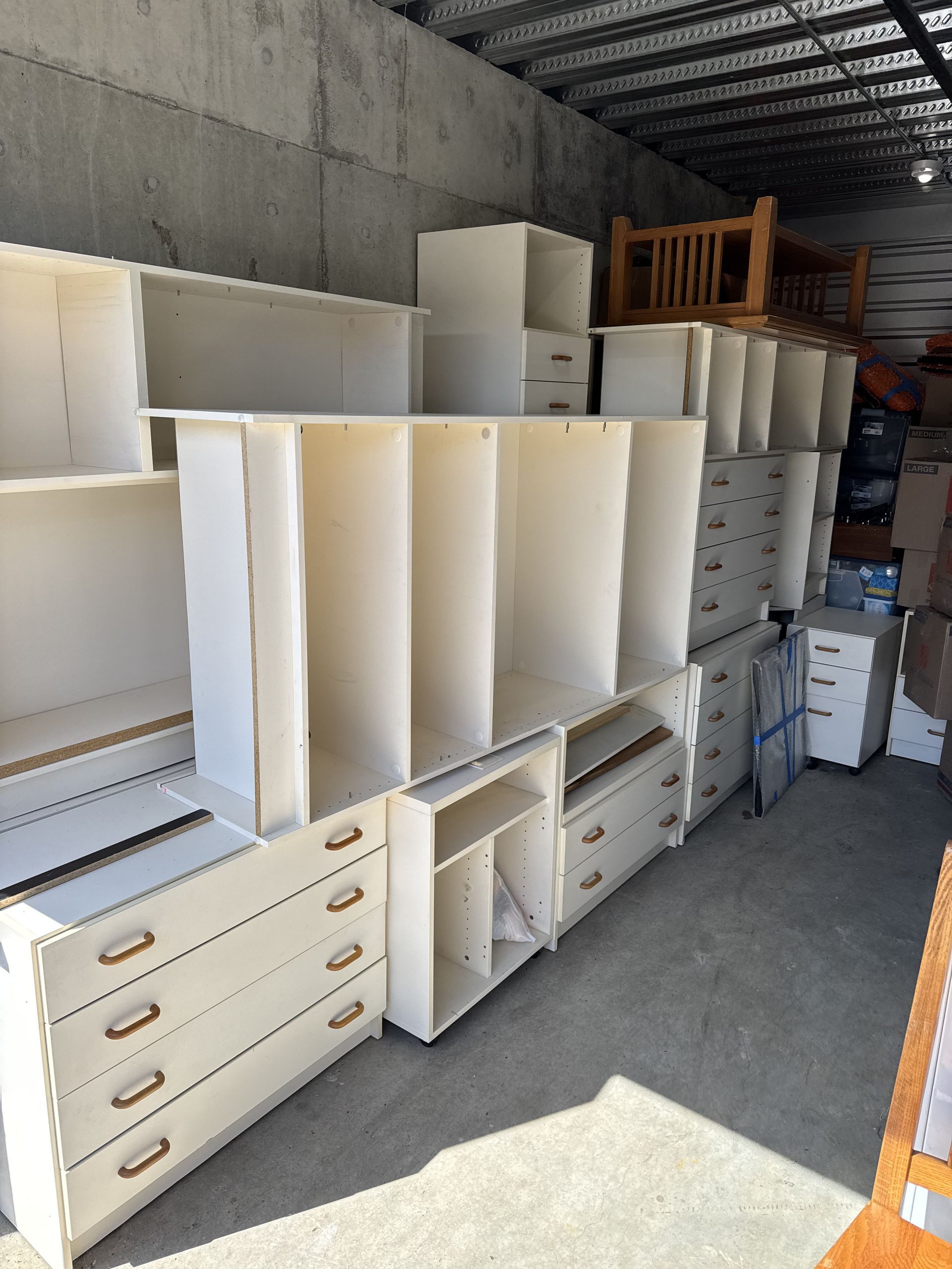 White furniture storage units stacked in a warehouse.