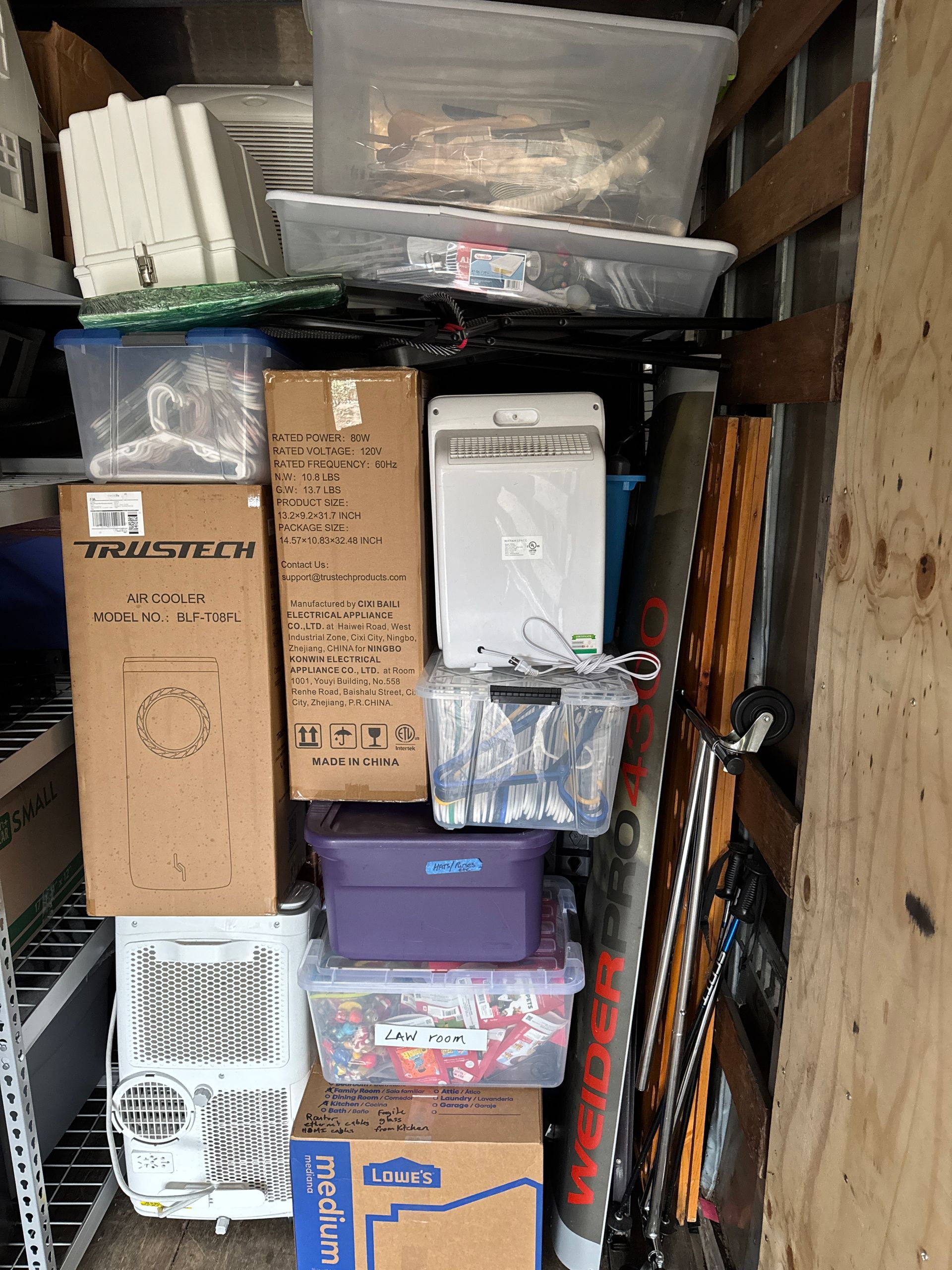 Boxes and containers packed in a cluttered storage space with various items visible.