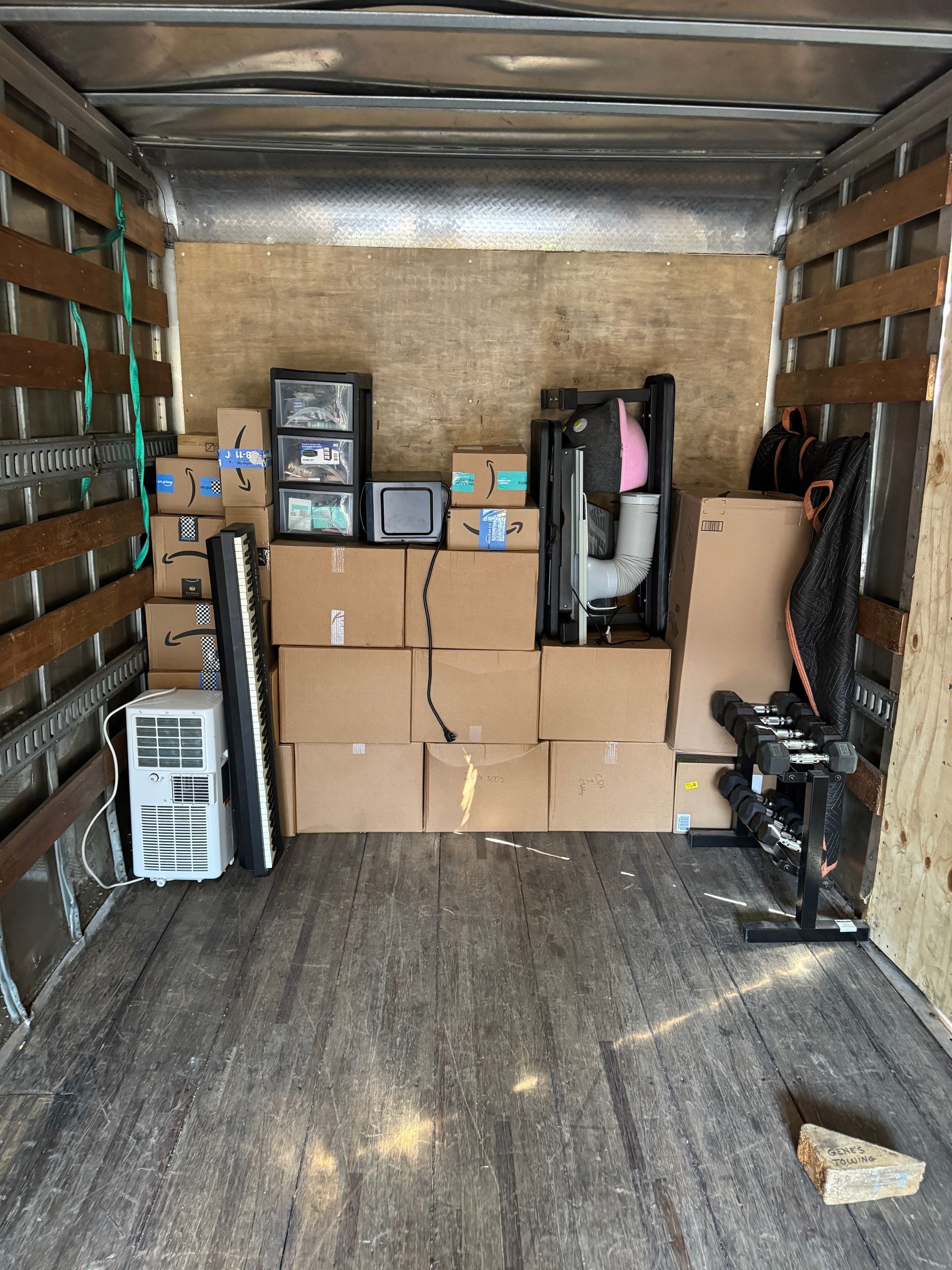 Moving truck interior loaded with boxes and furniture.