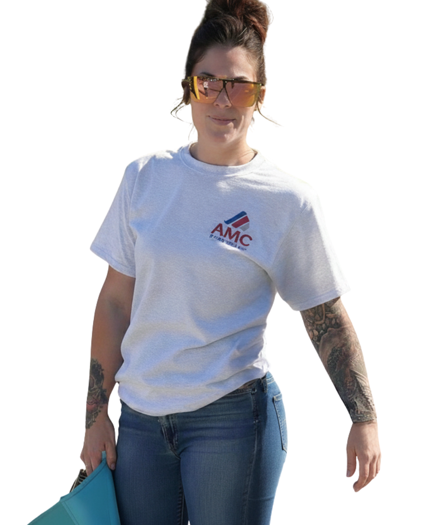 Woman wearing a light-colored shirt, jeans, and sunglasses, holding a turquoise folder.