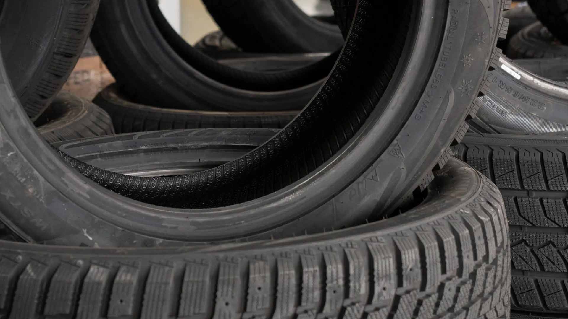 Un tas de pneus de voiture noirs usagés.