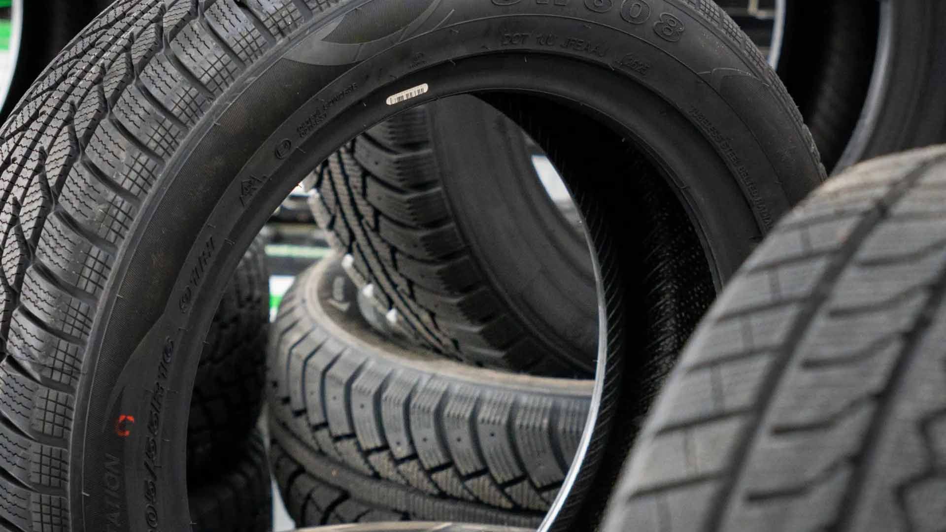 Pneus noirs empilés, laissant apparaître les sculptures de leurs bandes de roulement.