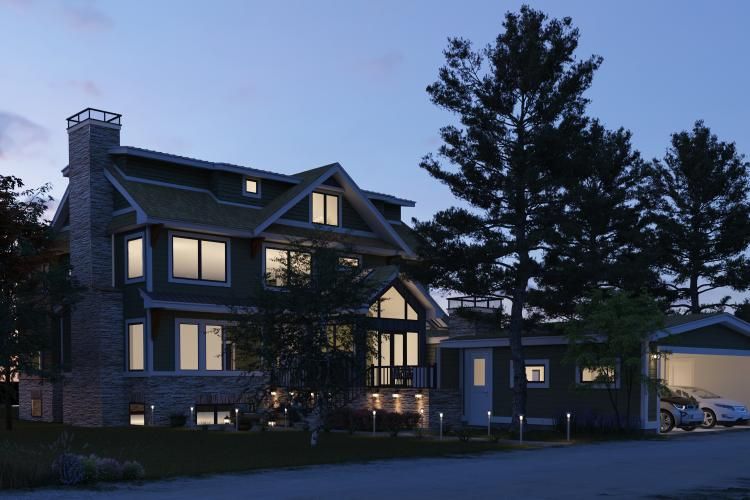 A large, multi-story green house with a stone chimney and illuminated windows at twilight, featuring an attached garage.