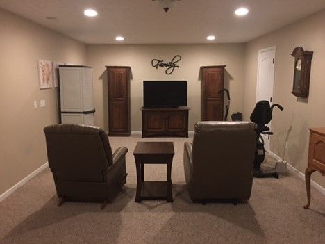 A living room with two chairs and a flat screen tv.