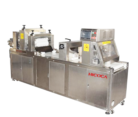 A stainless steel machine is sitting on top of a white table.