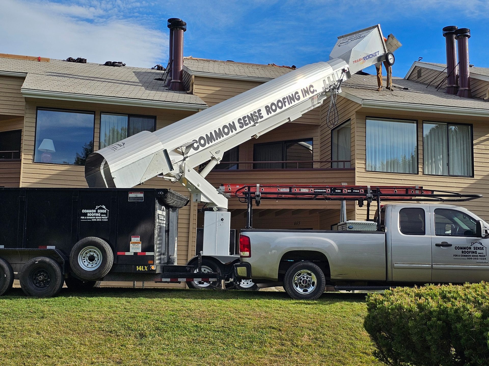 A truck with a crane attached to it is parked in front of a house.