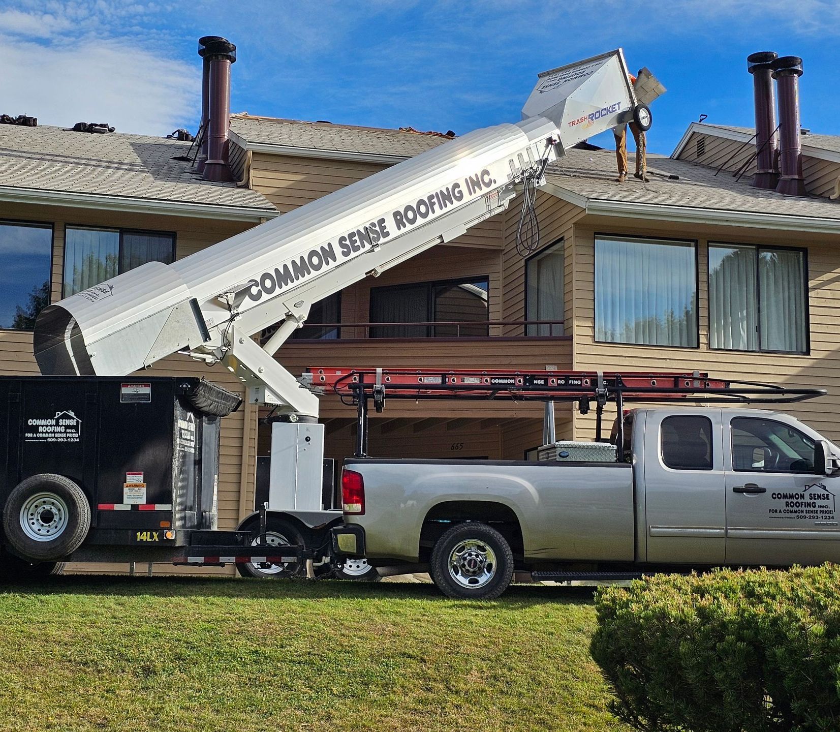 A truck with a crane attached to it is parked in front of a house.