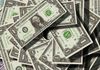 Pile of United States one-dollar bills, green and white, scattered.