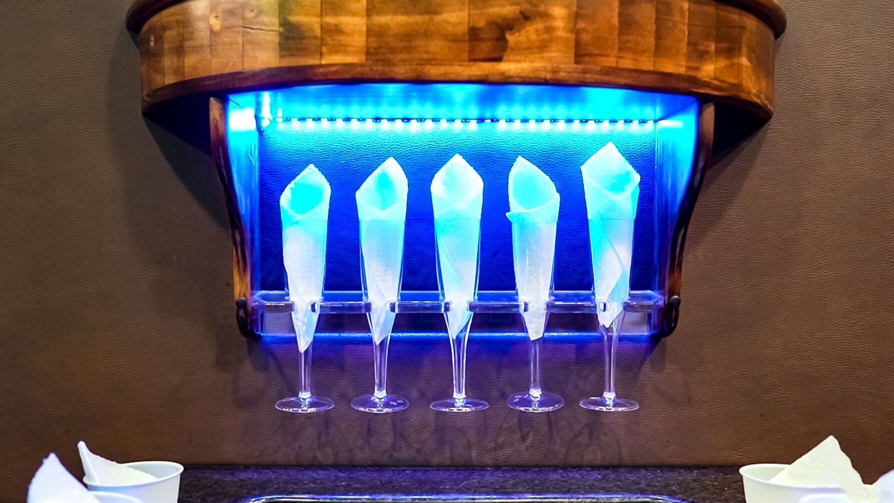 A row of wine glasses sitting under a blue light executive coaches premium chauffeur service memphis  tn