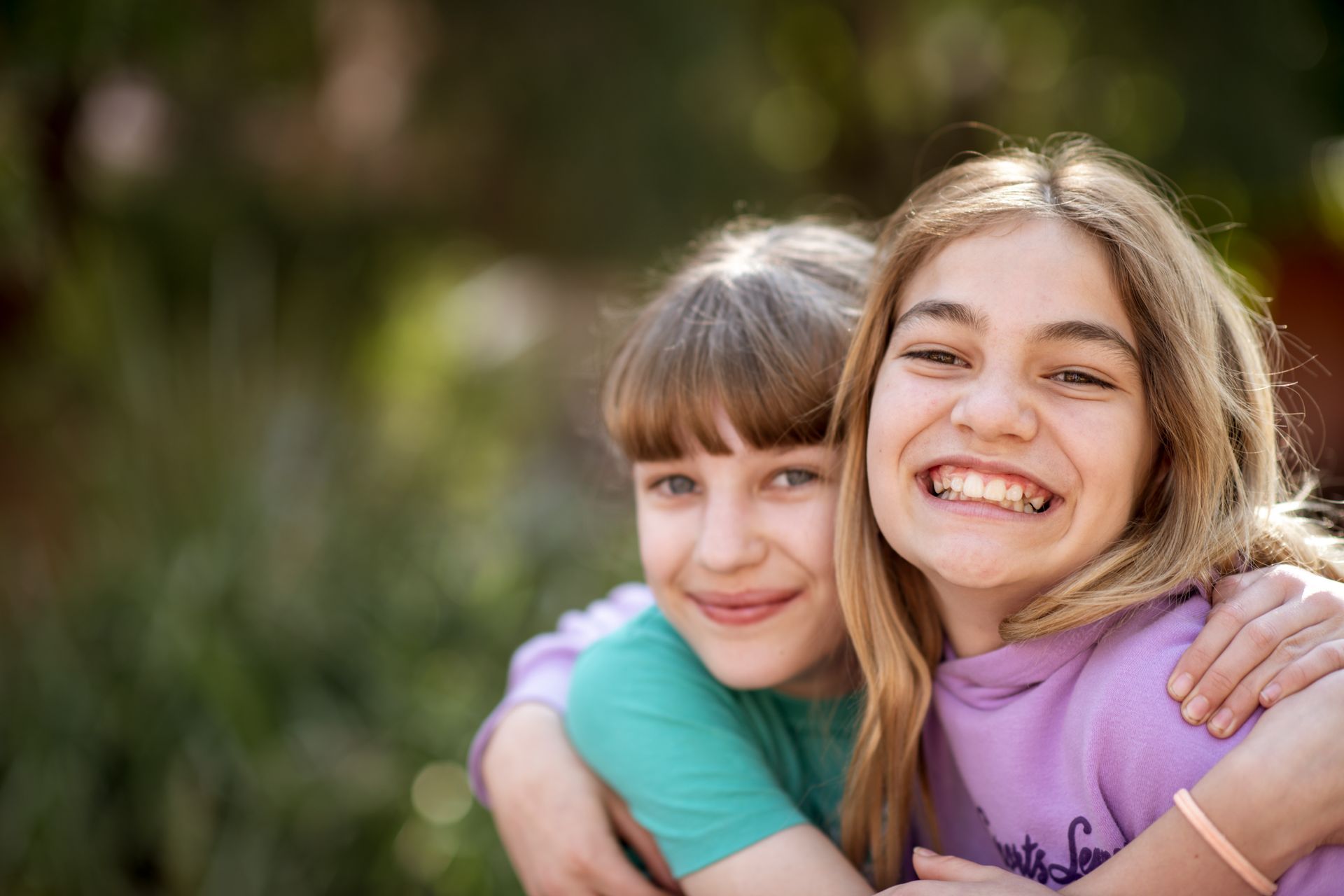 Two students embracing and smiling outdoors, illustrating friendship at WCSS