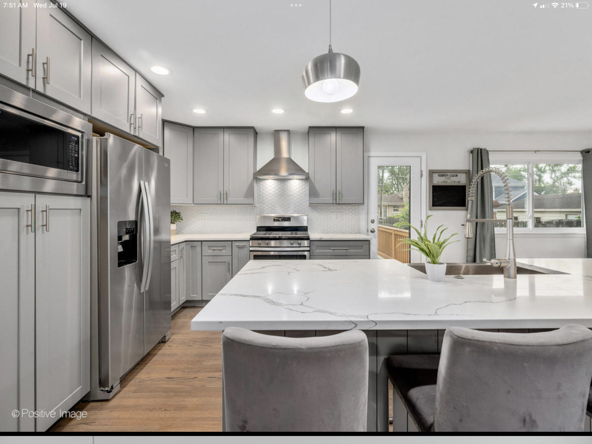 A kitchen with stainless steel appliances and white counter tops