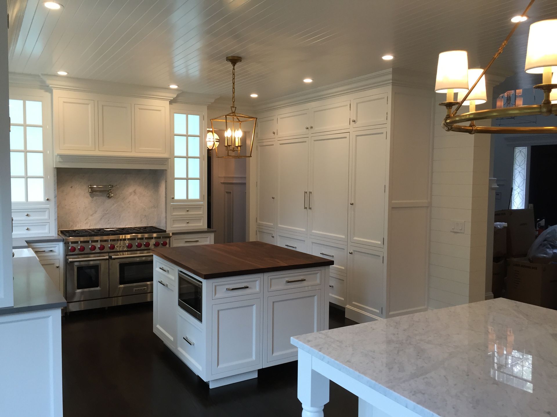 A kitchen with white cabinets and a large island in the middle