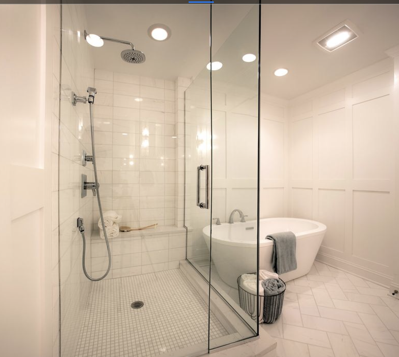 A bathroom with a tub and shower with glass doors