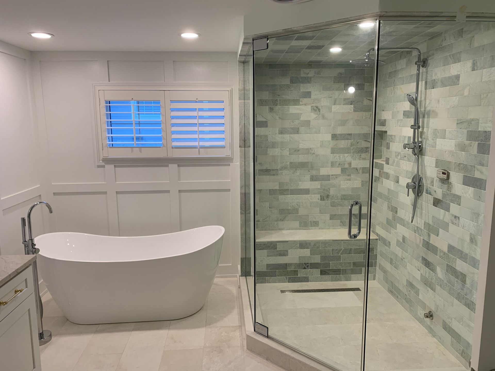 A bathroom with a tub , shower and window.