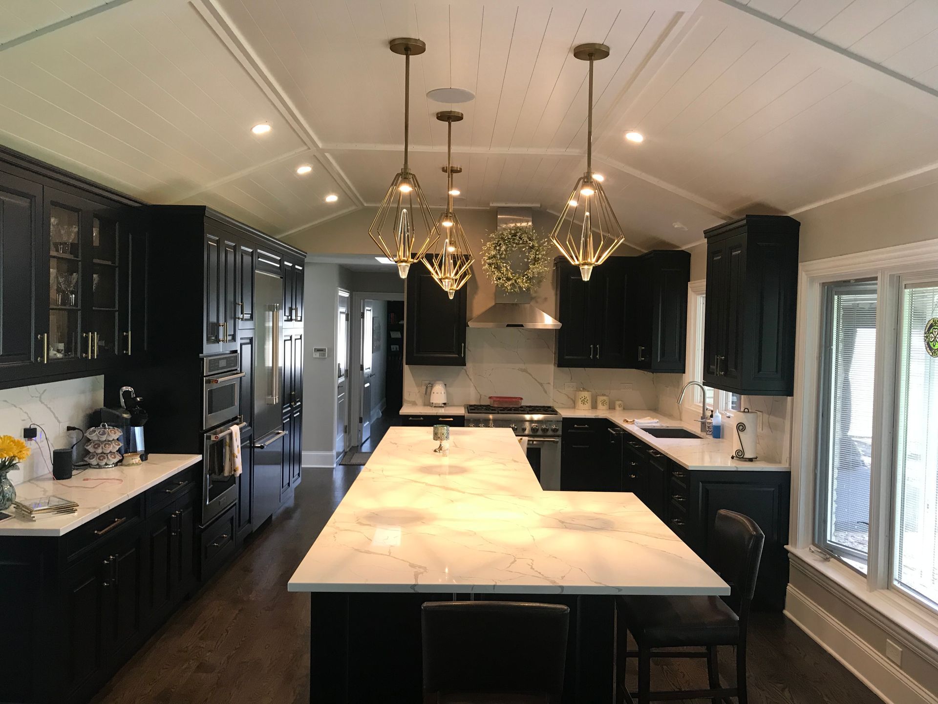 A kitchen with black cabinets and white counter tops