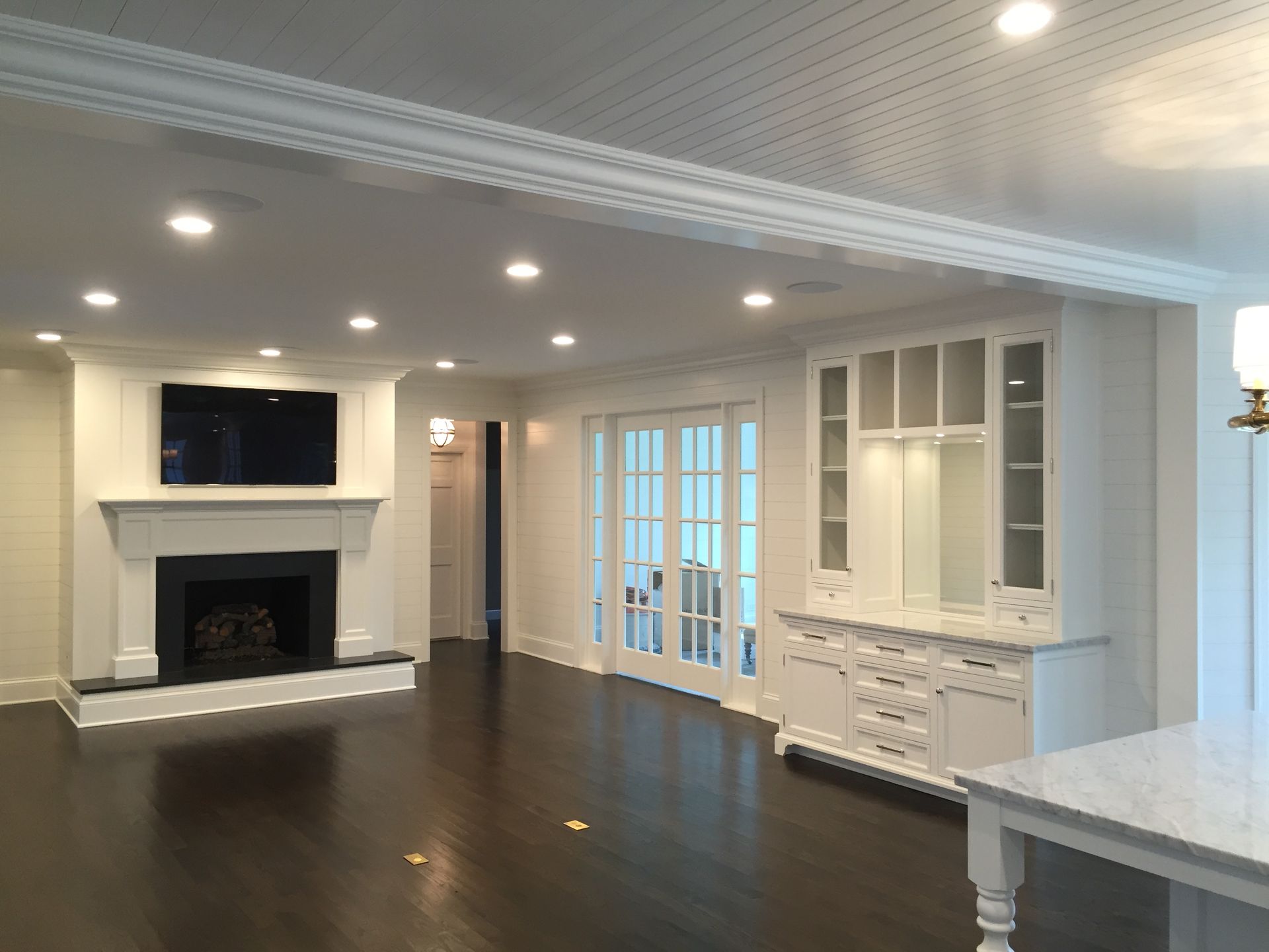 A living room with a fireplace and a television on the wall.