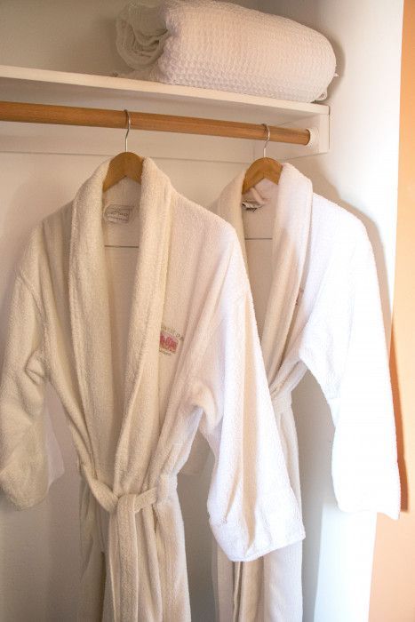 Two white bathrobes hanging in a guest closet at Southwest Inn Sedona