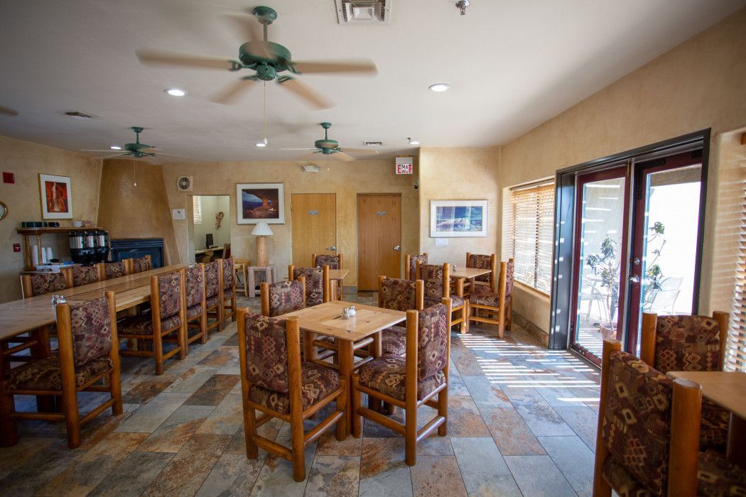 Large room with tables, chairs, and ceiling fan at Southwest Inn Sedona