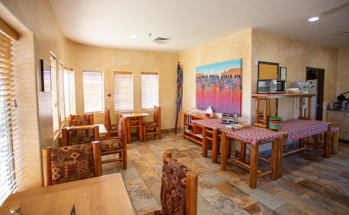 Large room with tables, chairs, and artwork on the wall at Southwest Inn Sedona