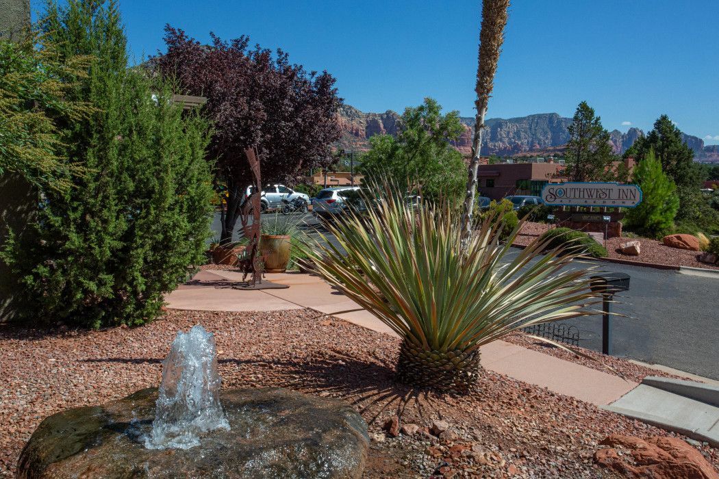 Fountain in the center of a lush garden at Southwest Inn Sedona