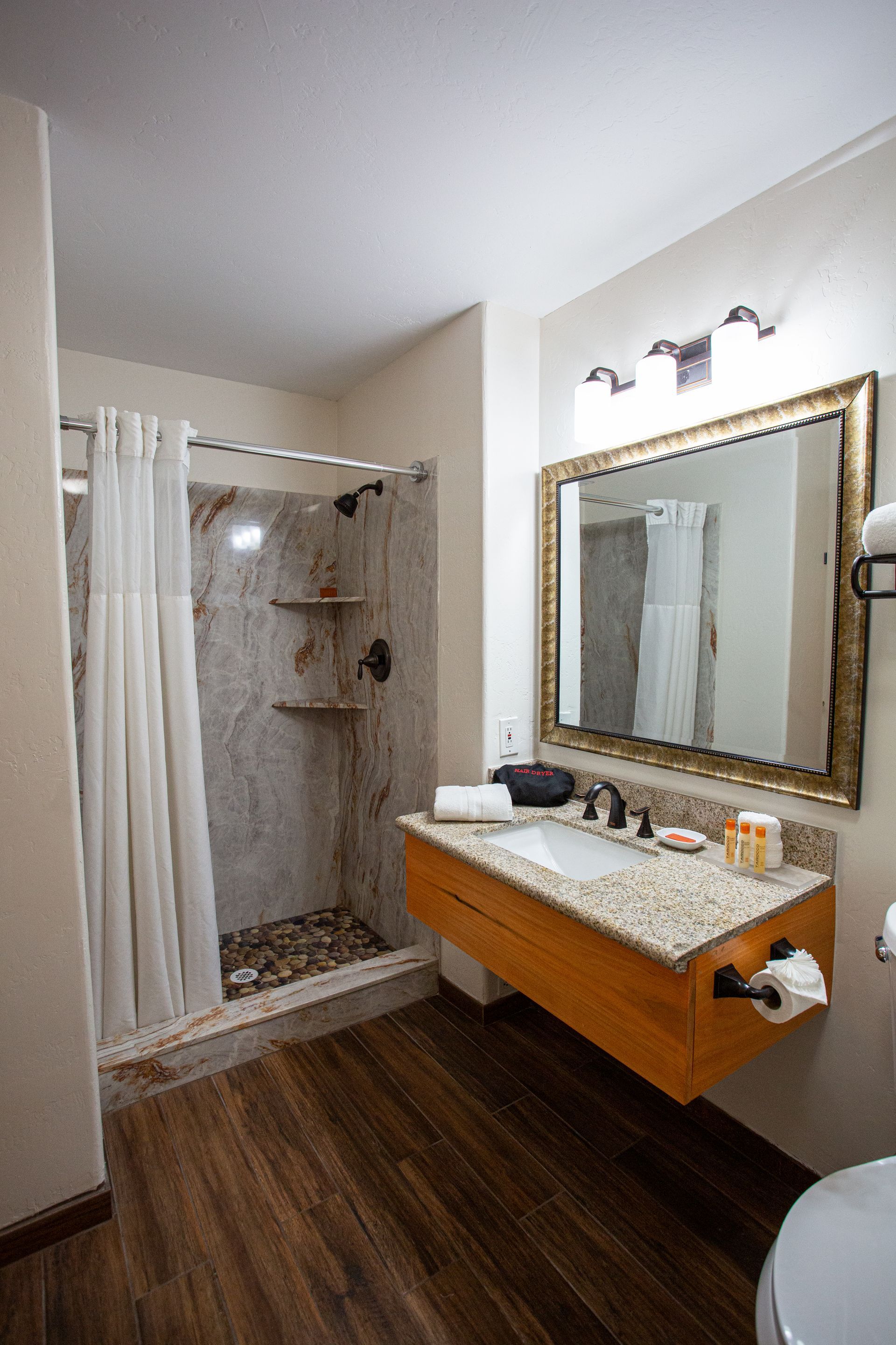 A bathroom with a sink , toilet and shower.
