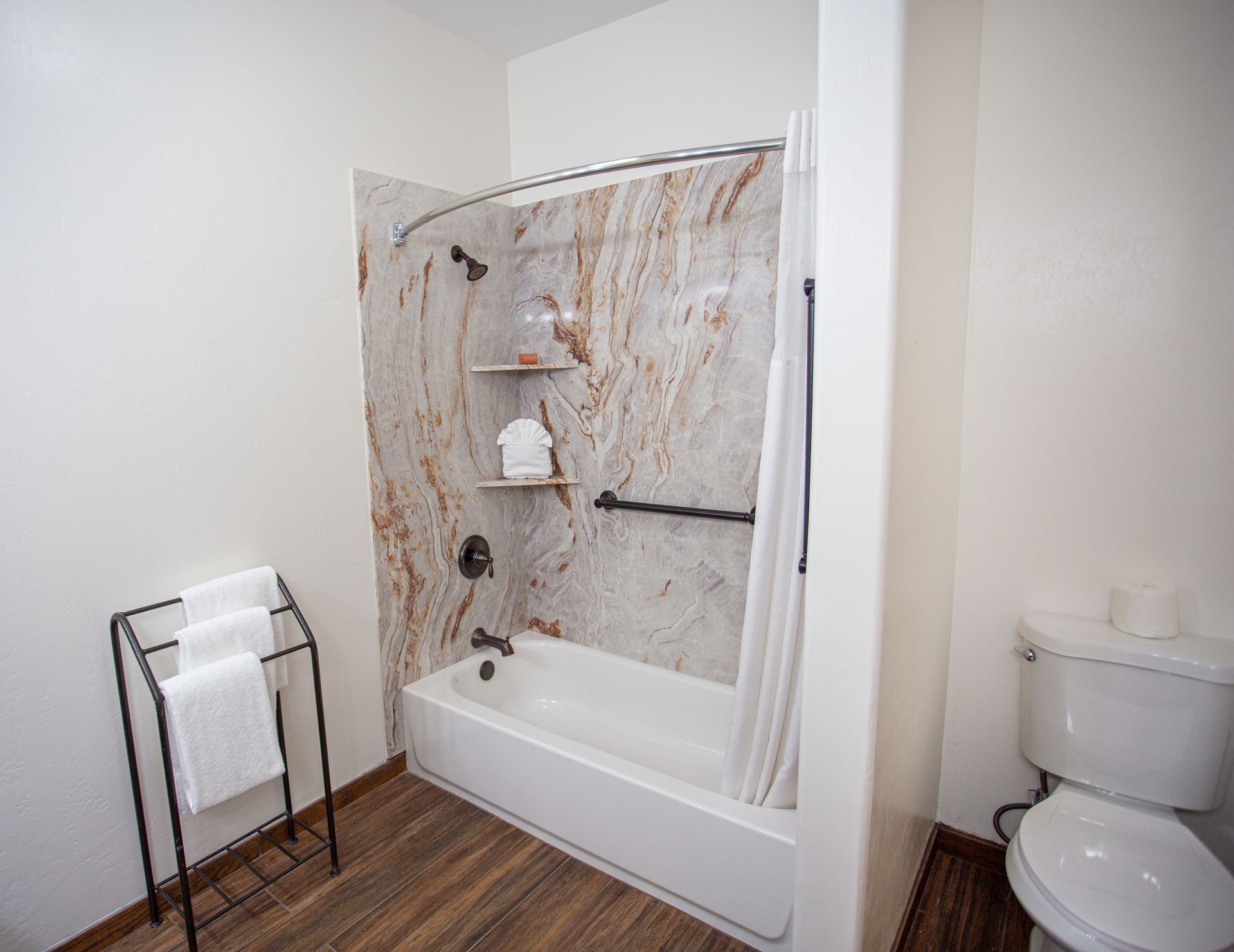 A bathroom with a tub , toilet and shower.