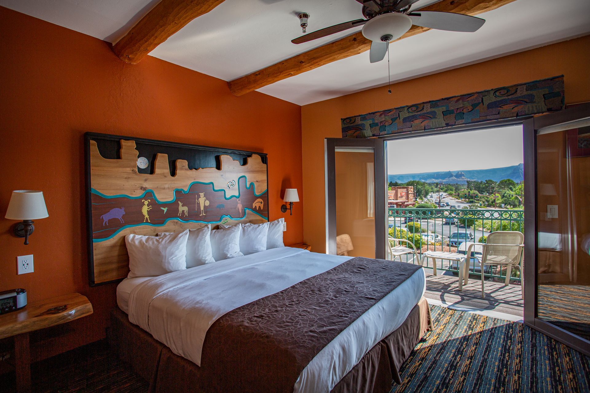 A hotel room with a large bed and a ceiling fan.