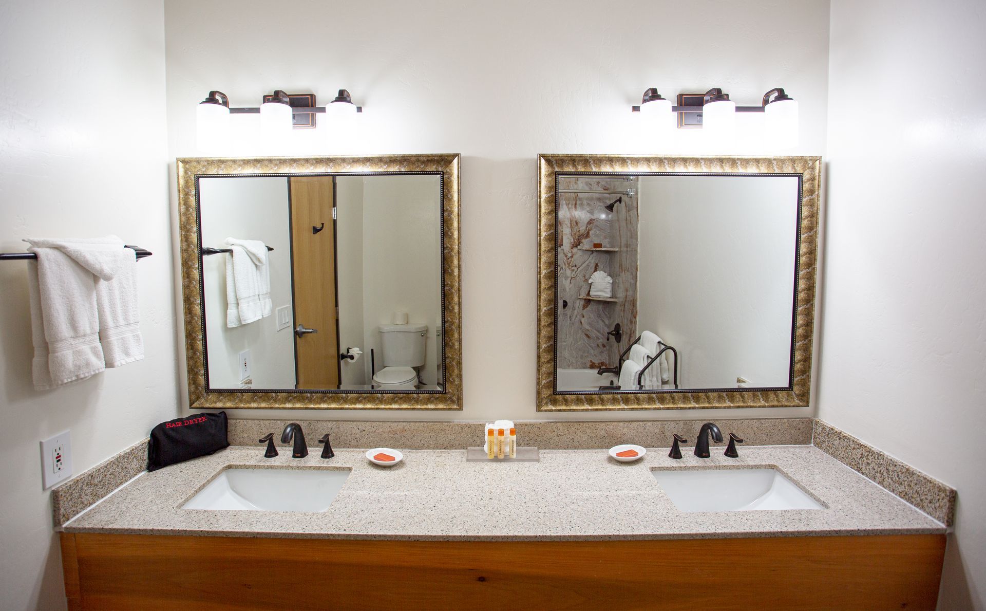 A bathroom with two sinks and two mirrors.