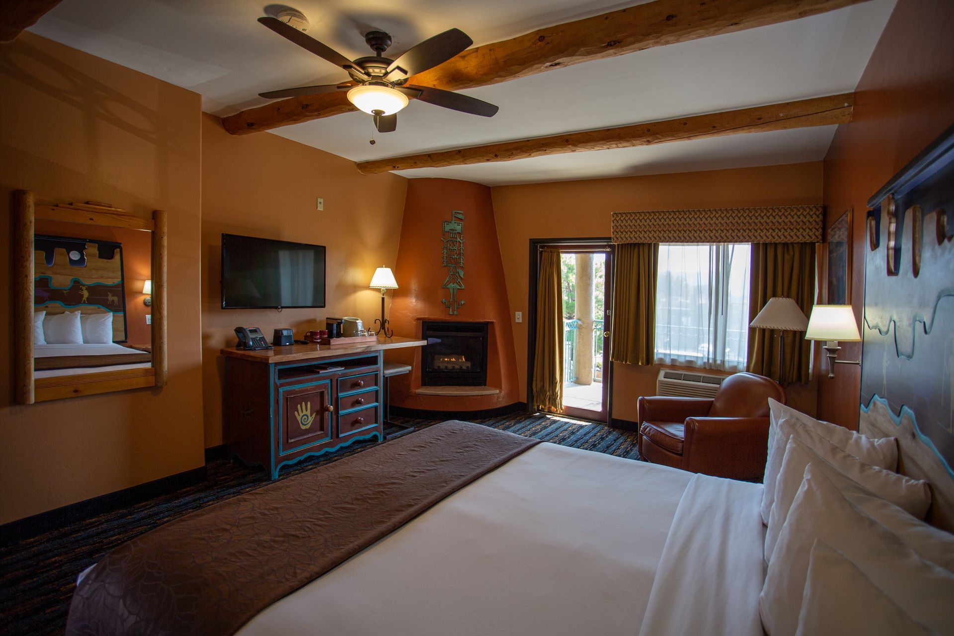 A hotel room with a king size bed , fireplace and television.