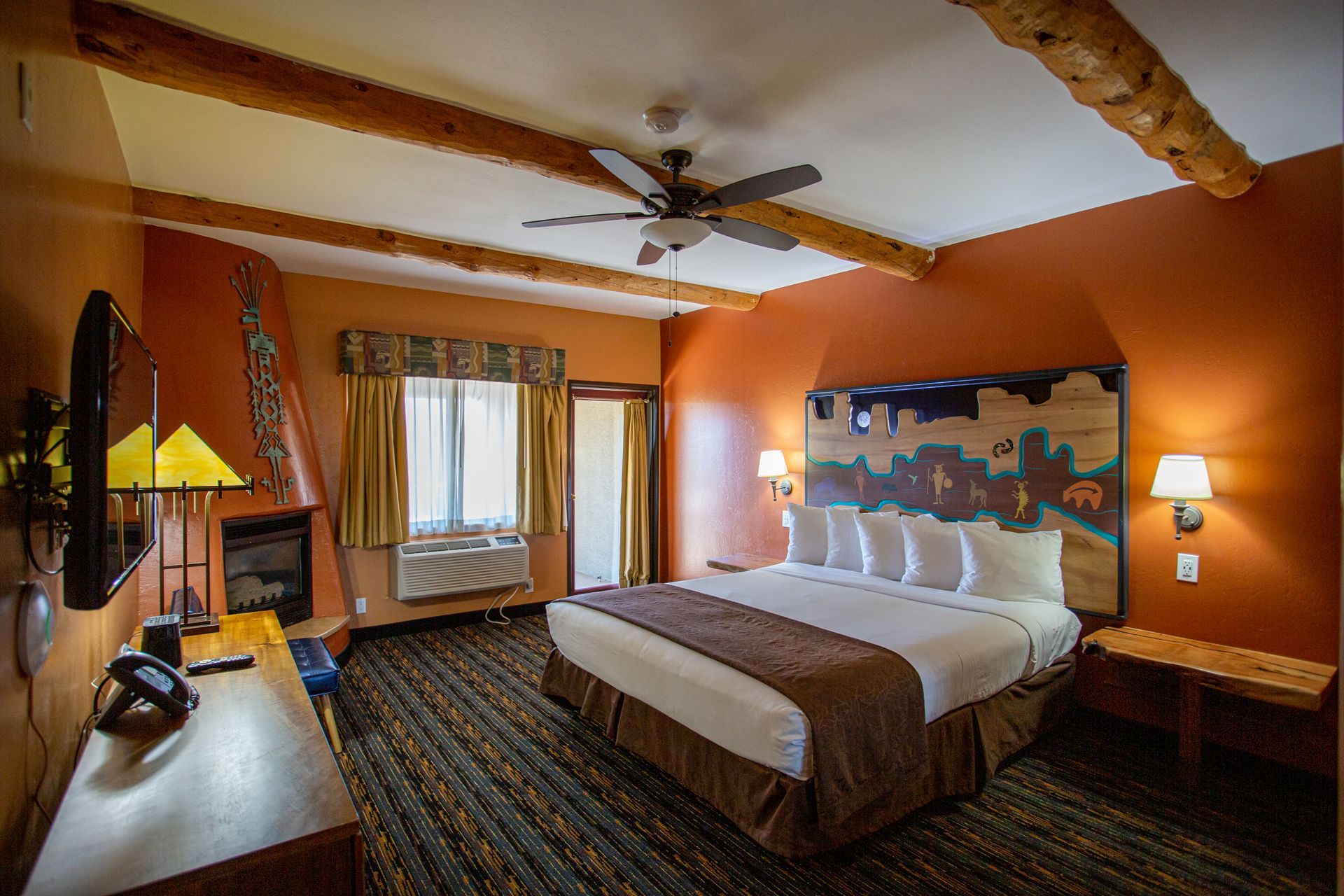 A hotel room with a king size bed and a fireplace.