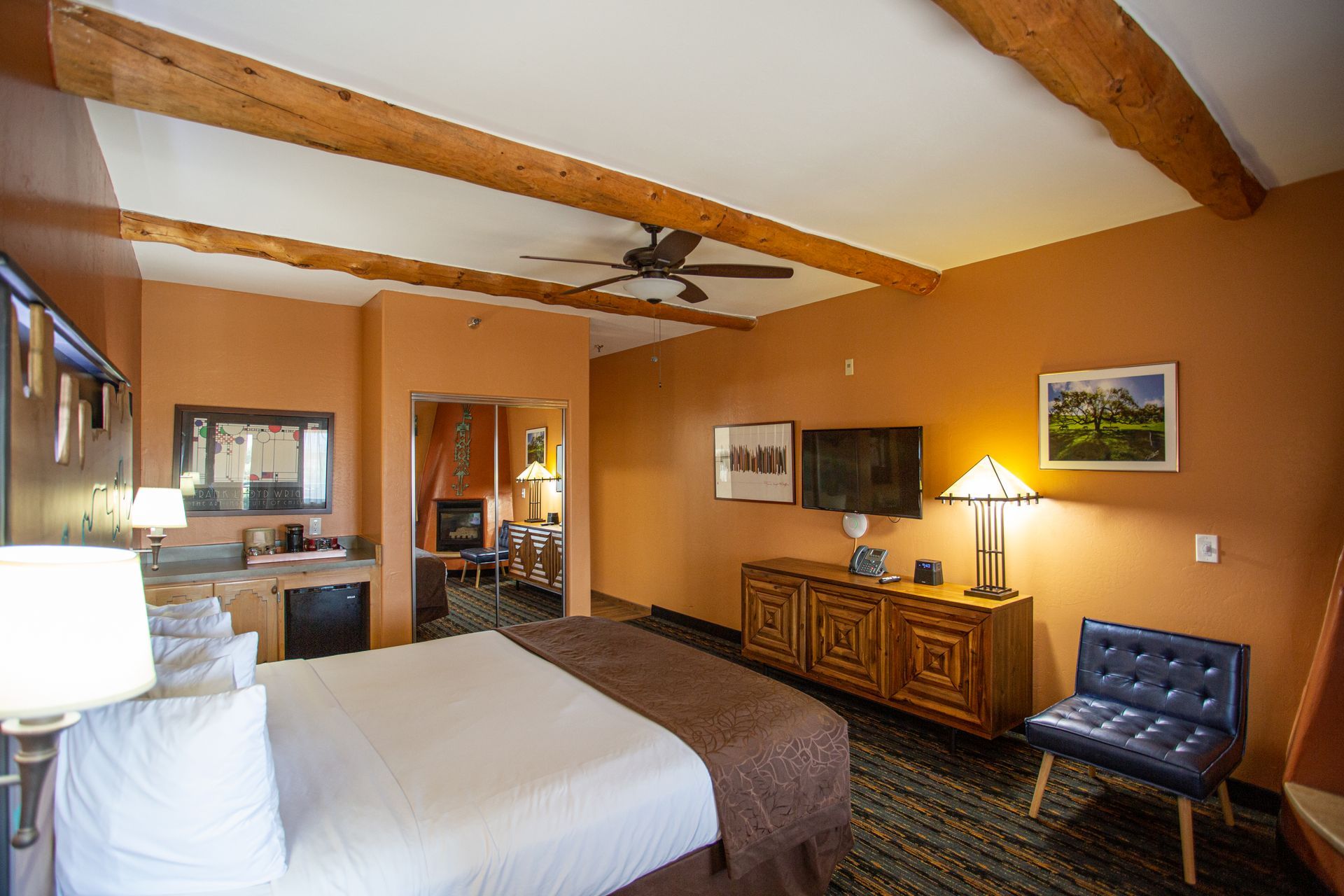 A hotel room with a king size bed and a wooden headboard.