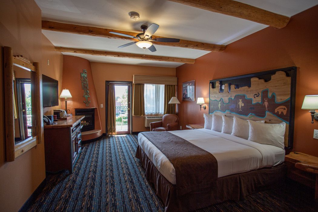 A hotel room with a king size bed and a fireplace.