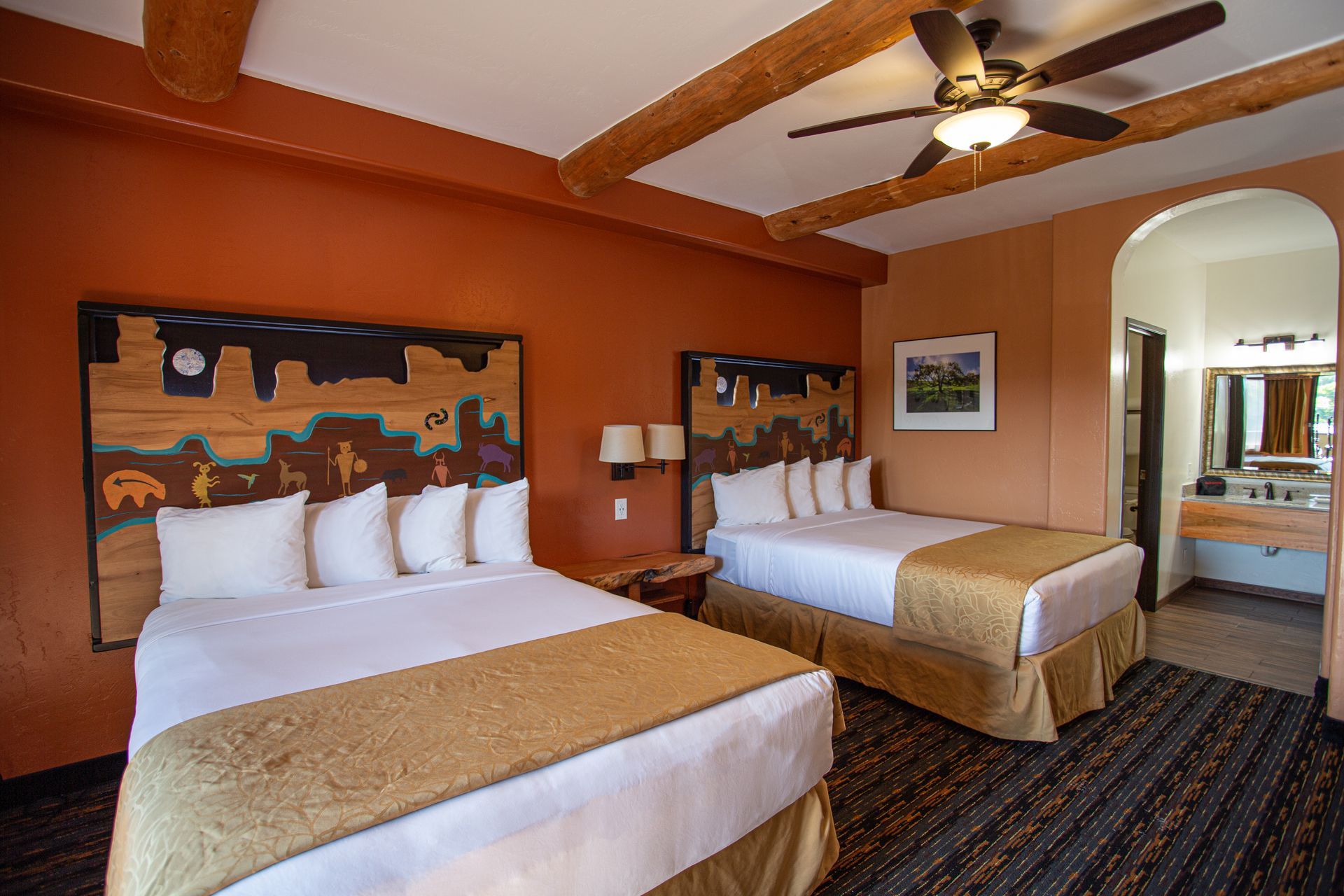 A hotel room with two beds and a ceiling fan.