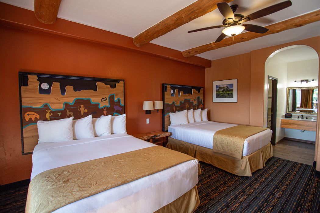 Spacious hotel room at Southwest Inn Sedona with two beds and a ceiling fan