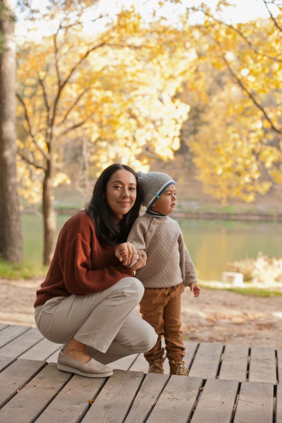 A man is giving a boy a piggyback ride while sitting on a couch.