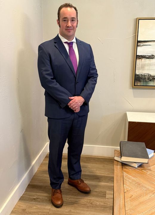 A man in a suit and tie is standing in a room.