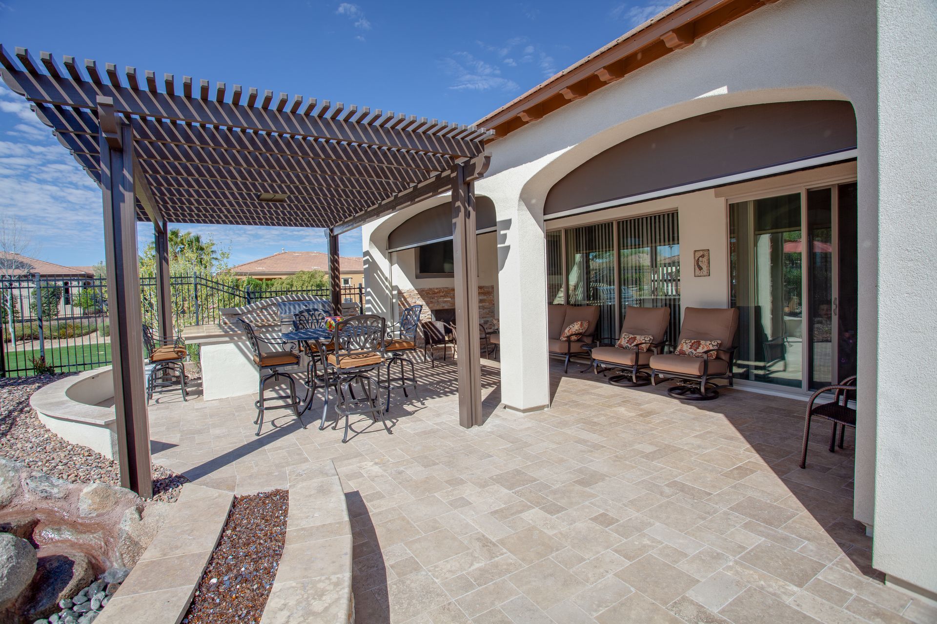 Outdoor patio with pergola, seating area, and sliding glass doors.