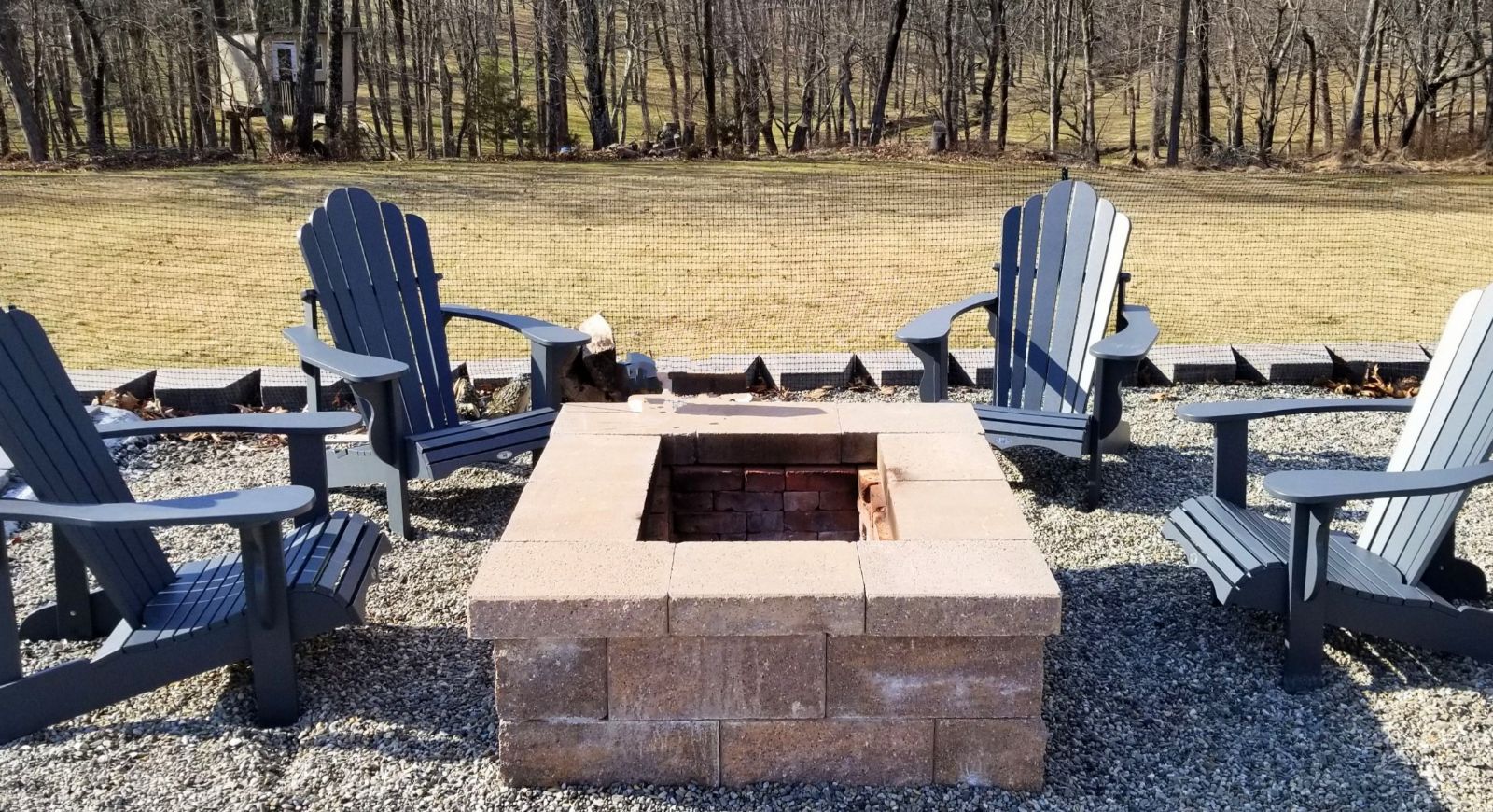 A group of chairs are sitting around a fire pit.