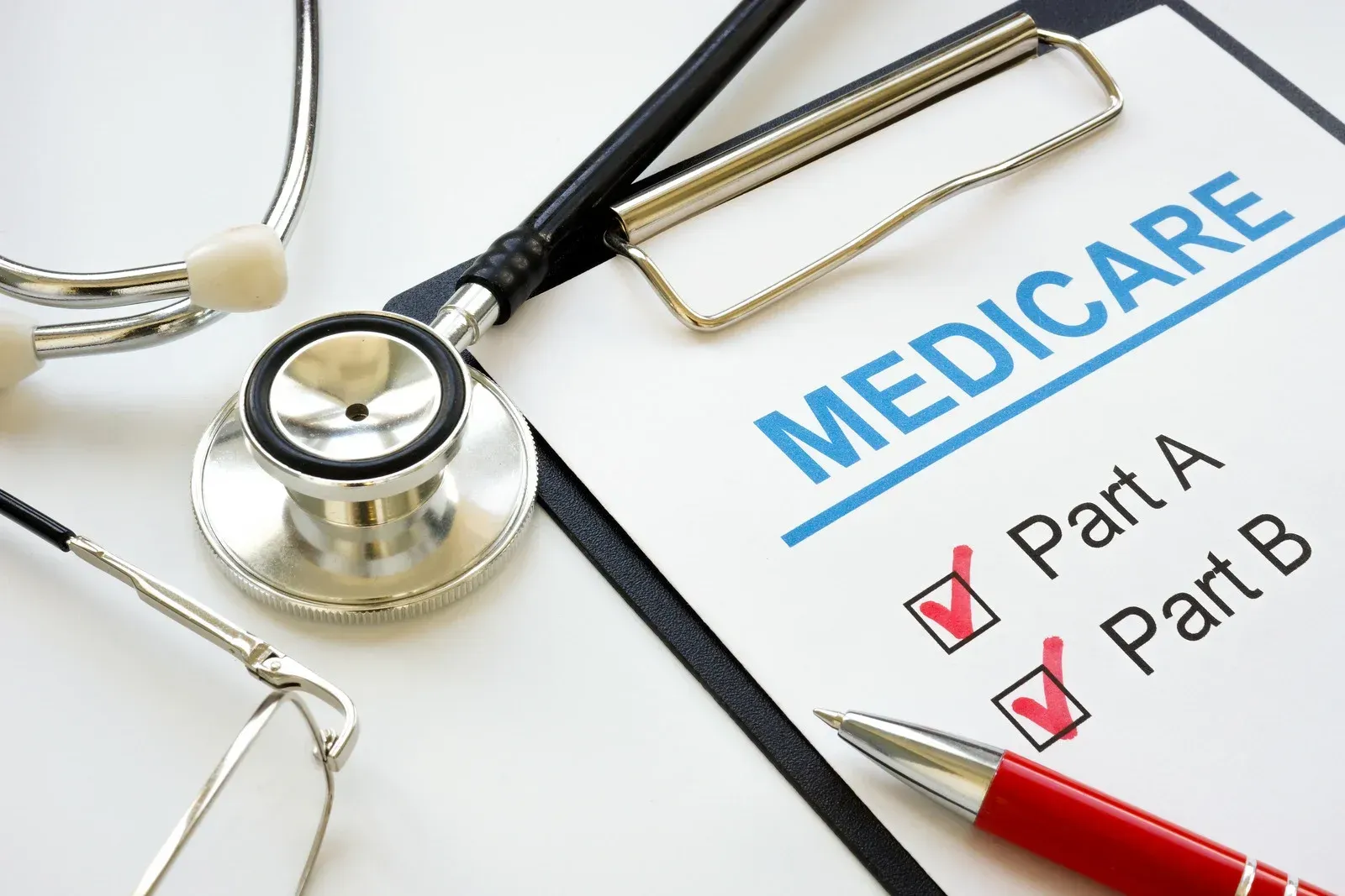 A clipboard with a stethoscope and a pen on it that says medicare