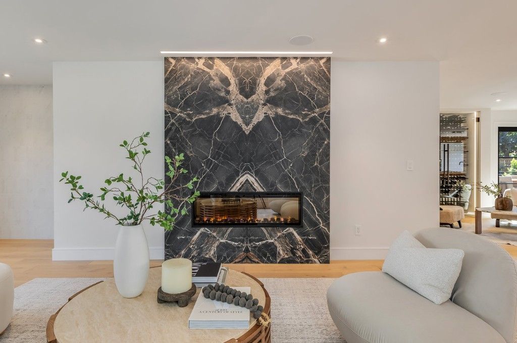 Living room with marble fireplace, sofa, and coffee table.