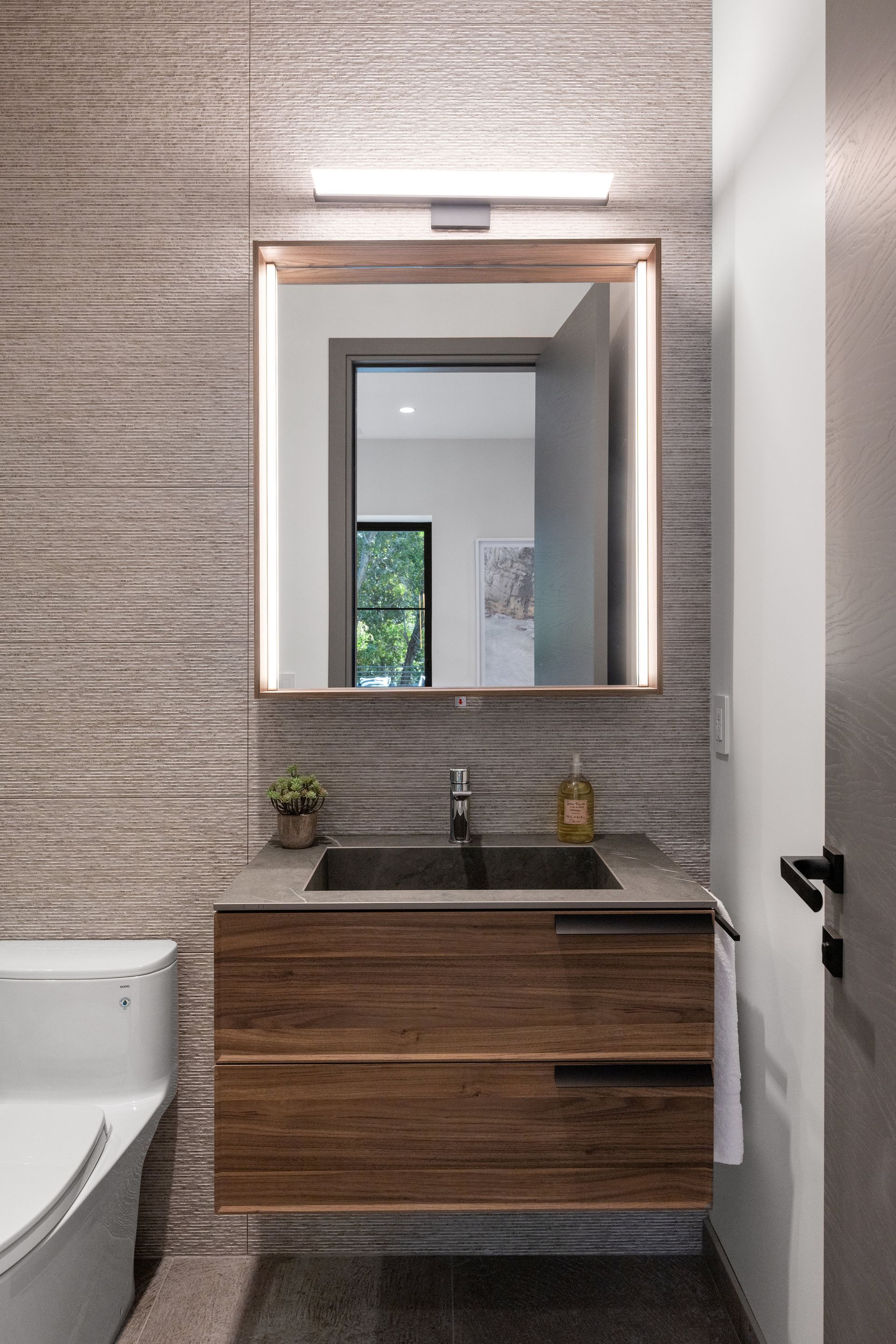 A bathroom with a sink , toilet and mirror