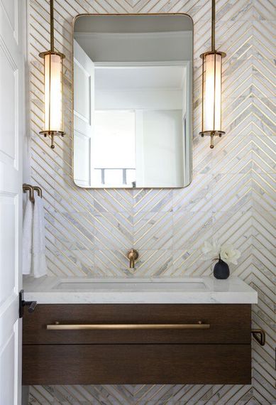 A bathroom with a sink , mirror , and light fixtures.