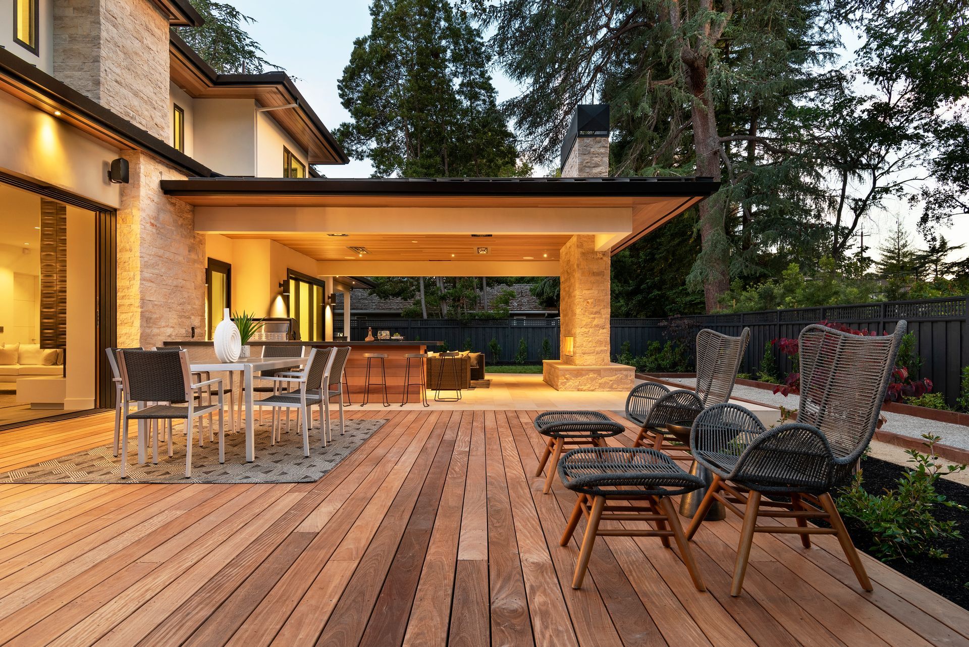 There is a large wooden deck with a table and chairs on it.