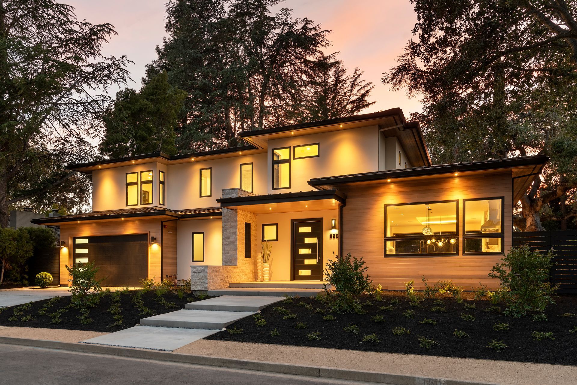 A large house with a lot of windows is lit up at night