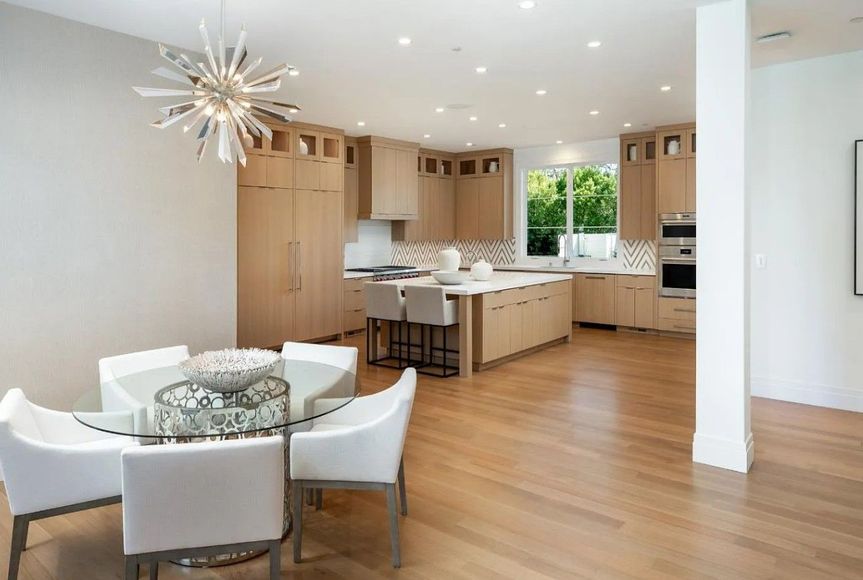 There is a dining room table and chairs in the middle of the kitchen.