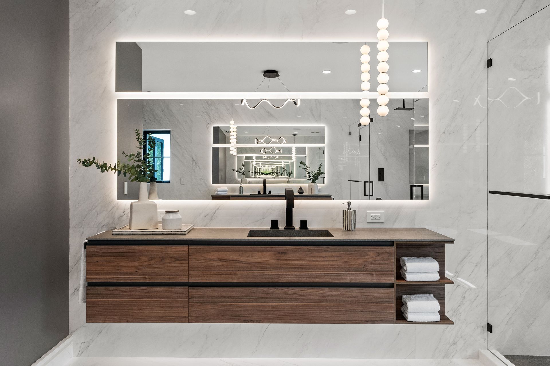 A bathroom with a large mirror , sink , and bathtub.