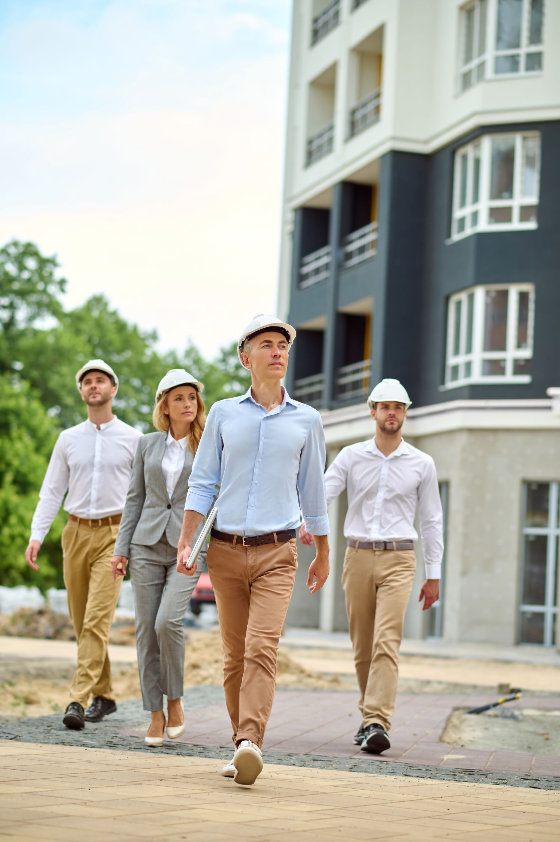 A group of people are walking in front of a building under construction.