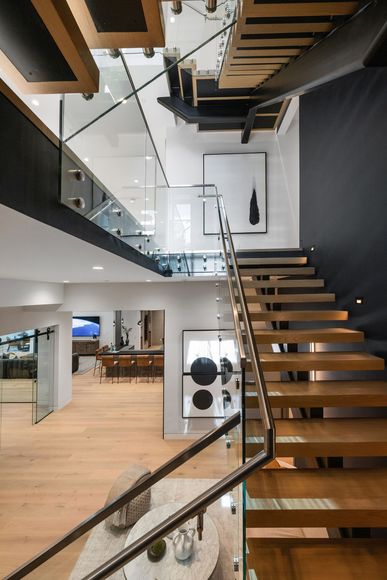 A modern staircase with a glass railing in a house